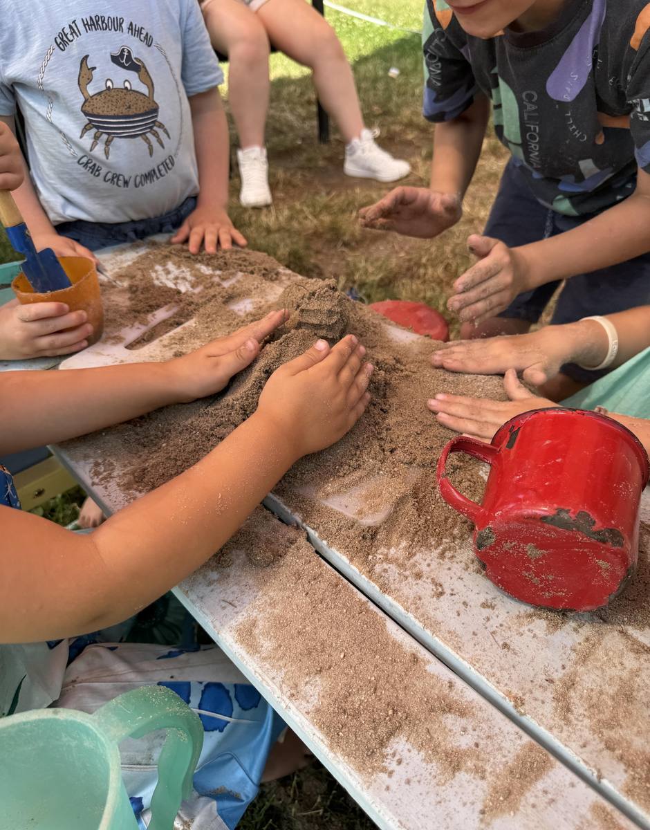 Kinder erkunden Sand und Erde mit den Händen